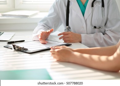 Arzt und Patient diskutieren etwas, nur Hände am Tisch
