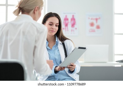 Doctor And Patient Discussing Something While Sitting At The Table . Medicine And Health Care Concept