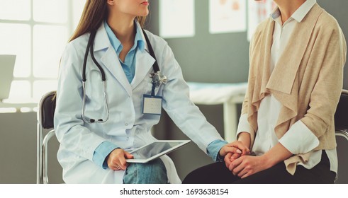Arzt und Patient diskutieren etwas während sie am Tisch sitzen. Konzept der Medizin und des Gesundheitswesens