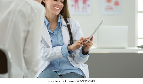 Arzt und Patient diskutieren etwas während sie am Tisch sitzen. Konzept der Medizin und des Gesundheitswesens