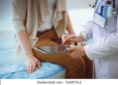 Arzt und Patient diskutieren etwas während sie am Tisch sitzen. Medizin und Gesundheitswesen. Arzt und Patient