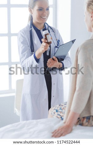 Similar – Doctor giving a prescription to senior patient