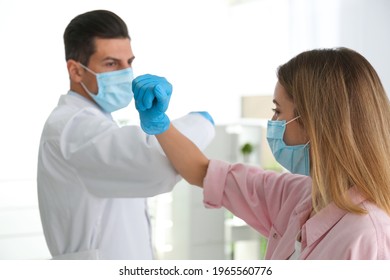 Doctor And Patient Doing Elbow Bump Instead Of Handshake In Clinic. New Greeting During COVID-19 Pandemic