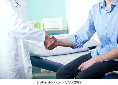 Doctor And Patient Handshake With Medical Equipment On The Background.