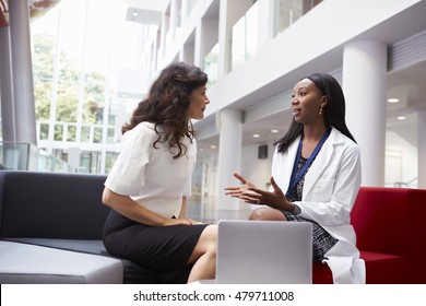 Doctor And Patient Having Meeting In Hospital Reception Area
