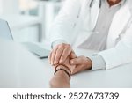 Doctor, patient and holding hands with empathy for consultation, news or understanding at clinic. Closeup, medical employee or client for sympathy, counseling or support together on desk at hospital