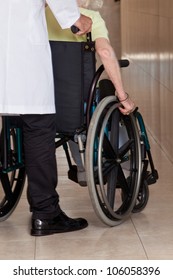 Doctor with patient on wheel chair at hospital.