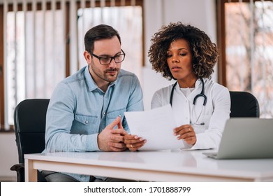 Doctor And Patient Reviewing Test Results Together.