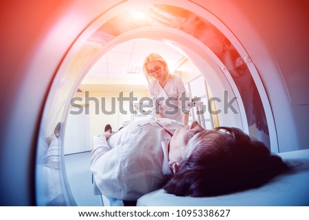 Doctor and patient in the room of computed tomography at hospital. Medical equipment.