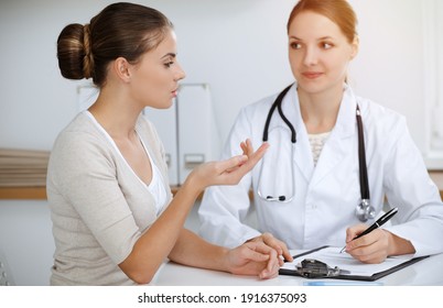 Doctor and patient sitting and discussing health examination results in sunny clinic office