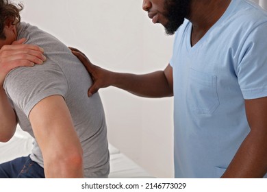 Doctor And Patient Suffering From Back Pain During Medical Exam. Chiropractic, Physiotherapy Concept.