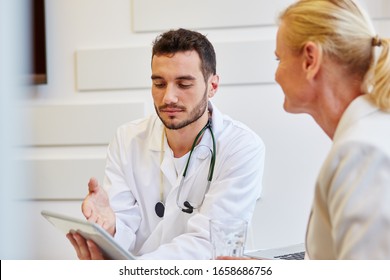 Doctor With Patient And Tablet PC During His Office Hours