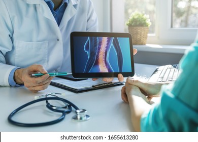 doctor and patient talking about back pain treatment in clinic office - Powered by Shutterstock