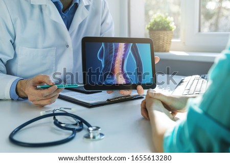 doctor and patient talking about back pain treatment in clinic office