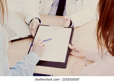 Doctor With Patients In Medical Office Sign A Contract. Healthcare Concept. Medical Insurance.