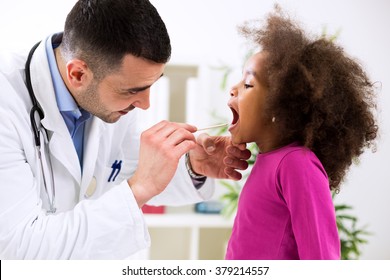 Doctor pediatrician examining cute smiling african girl, throat sick - Powered by Shutterstock