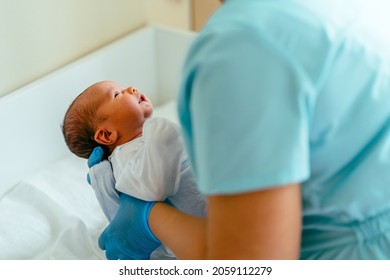 Doctor pediatrician examining new born baby boy in clinic. Nurse dressing infant baby boy. Medical checkup. Health care concept.