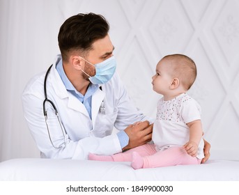 Doctor Pediatrician In Face Mask Examining Baby Patient Having Medical Checkup In Hospital Indoors. Sick Little Toddler On Appointment In Clinic. Child's Healthcare Concept