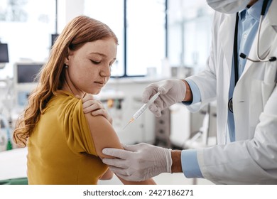 Doctor, pediatrician injecting vaccine into teenage girl arm. Concept of preventive health care and vaccination for teenagers. - Powered by Shutterstock