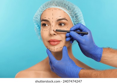 Doctor with pencil preparing patient for cosmetic surgery operation on light blue background, closeup - Powered by Shutterstock