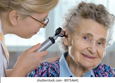 Doctor Performing Ear Exam With Otoscope On A  Senior Patient