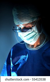 Doctor Performing  Surgery In A Dark Background