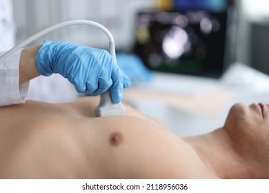 Doctor performs chest ultrasound on man in hospital closeup