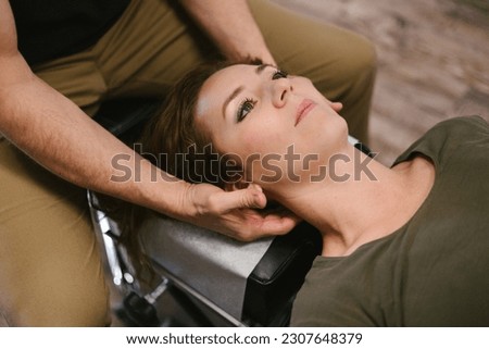 Doctor performs neck alignment on female patient in office