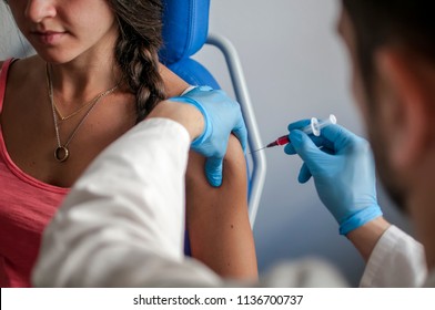Doctor performs vaccination on young girl