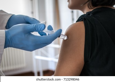 Doctor performs vaccination on young girl