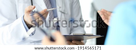 Doctor with phonendoscope holds pen and folder with documents in closeup conversation with another doctor. Medical advisory concept.
