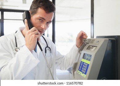 Doctor phoning in the hospital corridor, Healthcare workers in the Coronavirus Covid19 pandemic - Powered by Shutterstock