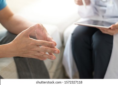 Doctor physician consulting with male patients in hospital exam room. Men's health concept - Shutterstock ID 1572327118