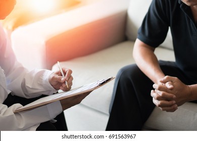 Doctor Physician Consulting With Male Patients In Hospital Exam Room. Men's Health Concept.