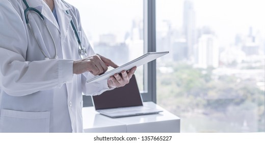 Doctor or physician holding mobile digital tablet for patient's health record in medical clinic or hospital office for professional online and emergency healthcare assistance service technology