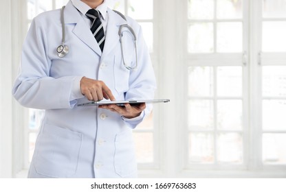 Doctor Or Physician Using Digital Tablet At Hospital Ward.Medicine Technology, Medical Research.  Copy Space.