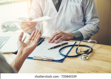 Doctor or physician writing diagnosis and giving a medical prescription to female Patient - Shutterstock ID 735845539