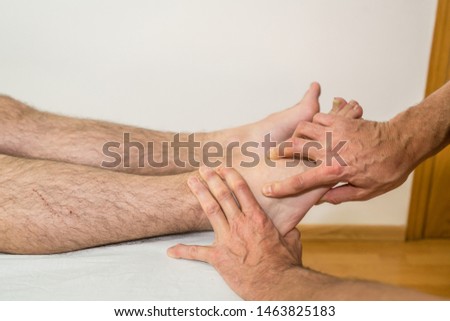 Doctor physiotherapist assisting a male patient while cuboides check of patient in a physio room, rehabilitation physiotherapy concept.