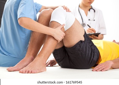 Doctor and physiotherapist examining twisted knee of the patient - Powered by Shutterstock