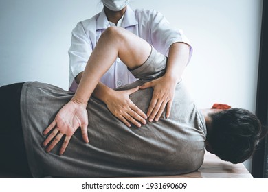 Doctor or Physiotherapist working examining treating injured back of athlete male patient, Doing the Rehabilitation therapy pain in clinic. - Shutterstock ID 1931690609