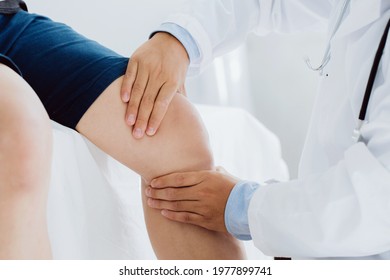 Doctor physiotherapist working examining treating injured knee of patient, his using the handle to the patient knee to check for pain. - Powered by Shutterstock