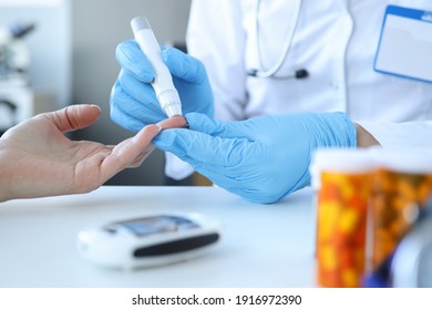 Doctor Piercing Patients Finger With Lancet In Clinic Closeup. Blood Glucose Control Concept