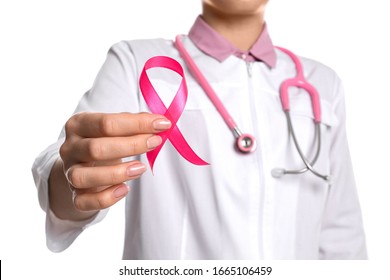Doctor with pink ribbon and stethoscope on white background, closeup. Breast cancer awareness