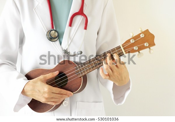 Doctor playing ukulele, Music therapy concept.
(Selective Focus)