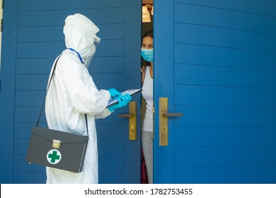 Doctor In PPE Suit Wear Face Mask And Gloves Visiting Patient At Home During Covid-19 Quarantine At Home. Check And Test Corona Virus For Protection Disease.
