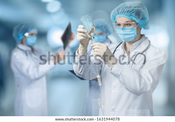 The doctor\
prepares an IV on blurred\
background.