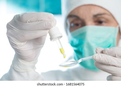 The Doctor Prepares An Oral Vaccine With Pipette And Spoon