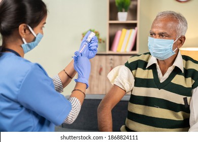 Doctor preparing vaccination shot to elderly patient by holding syringe at home - concept of home health check to seniors during coronavirus covid-19 pandemic - Powered by Shutterstock