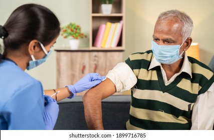 Doctor preparing vaccination shot to elderly patient by holding syringe at home - concept of home health check to seniors during coronavirus covid-19 vaccine immunization - Powered by Shutterstock