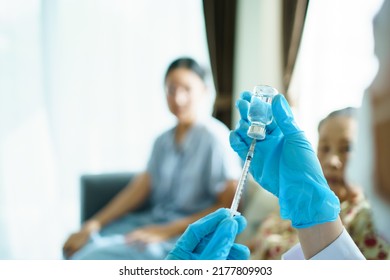 Doctor Preparing A Vaccine In Syringe For Injecting On Asian Elder Woman Arm Close Up With Copyspace. Granddaughter Take Her Grandmother To See A Doctor In Hospital And Getting A Vaccination.